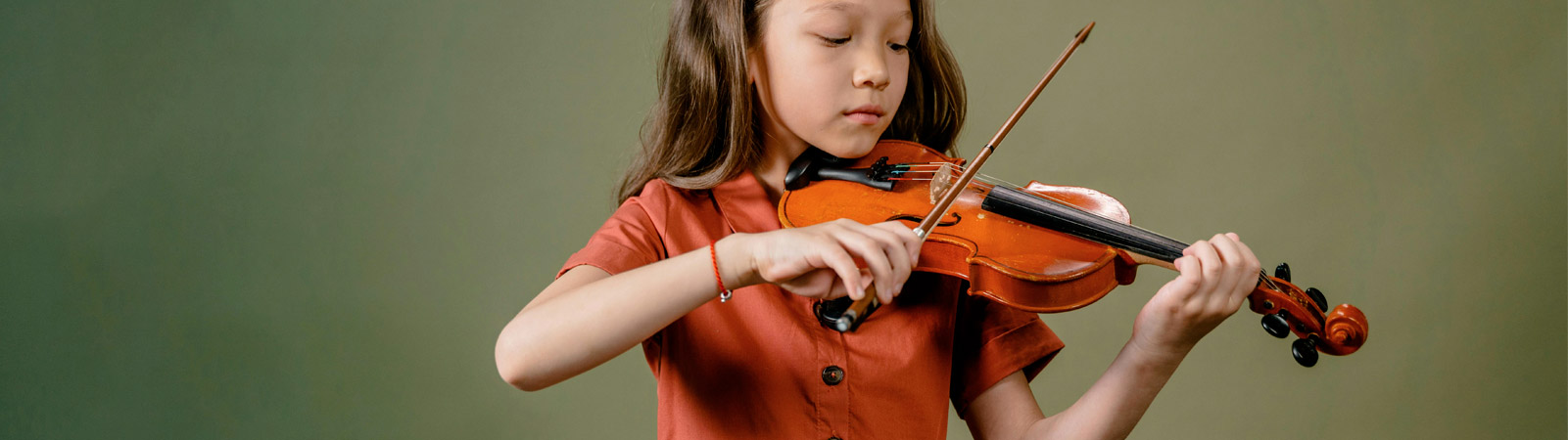 Les cours de musique de l'académie de Nivelles, représentés par une petite fille jouant du violon.